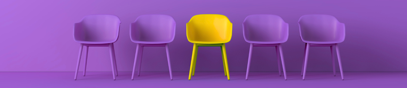 Lila Stühle in einer Reihe, einer davon ist gelb und sticht somit hervor