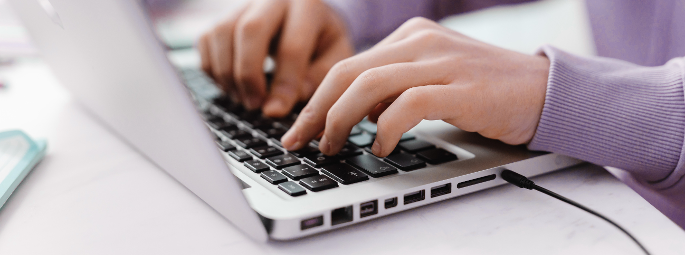 Zu sehen sind Hände, die auf eine Laptoptastatur tippen