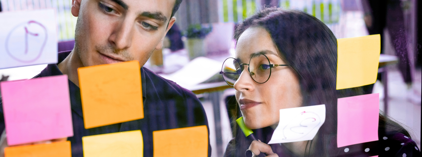 Zwei Menschen vor Post-Its, die sich besprechen